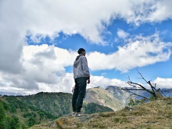 Rear view of man looking at mountain against sky