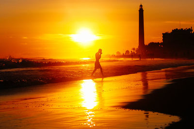 Silhouette of people in water at sunset
