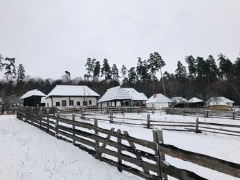 Built structure on snow covered field against sky