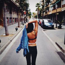Woman standing on road in city