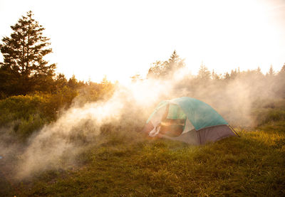 Tent on field against trees and sky