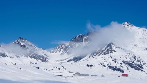 Scenic view of snowcapped mountains against clear blue sky