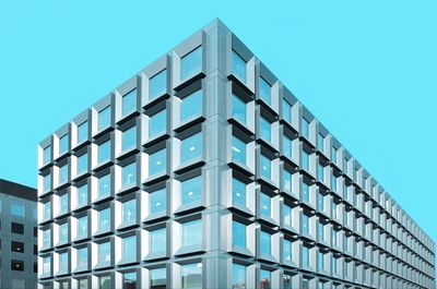 Low angle view of modern building against clear blue sky