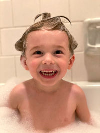 Portrait of smiling boy in bathtub