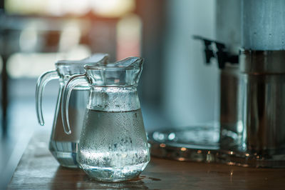 Water in jugs on table at home