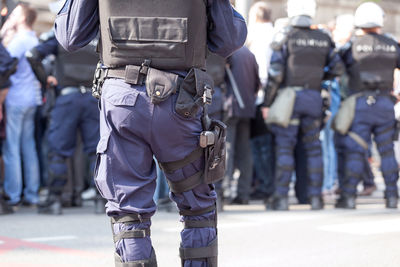 Rear view of police standing on street