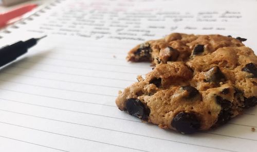 High angle view of chocolate chip cookie on notebook