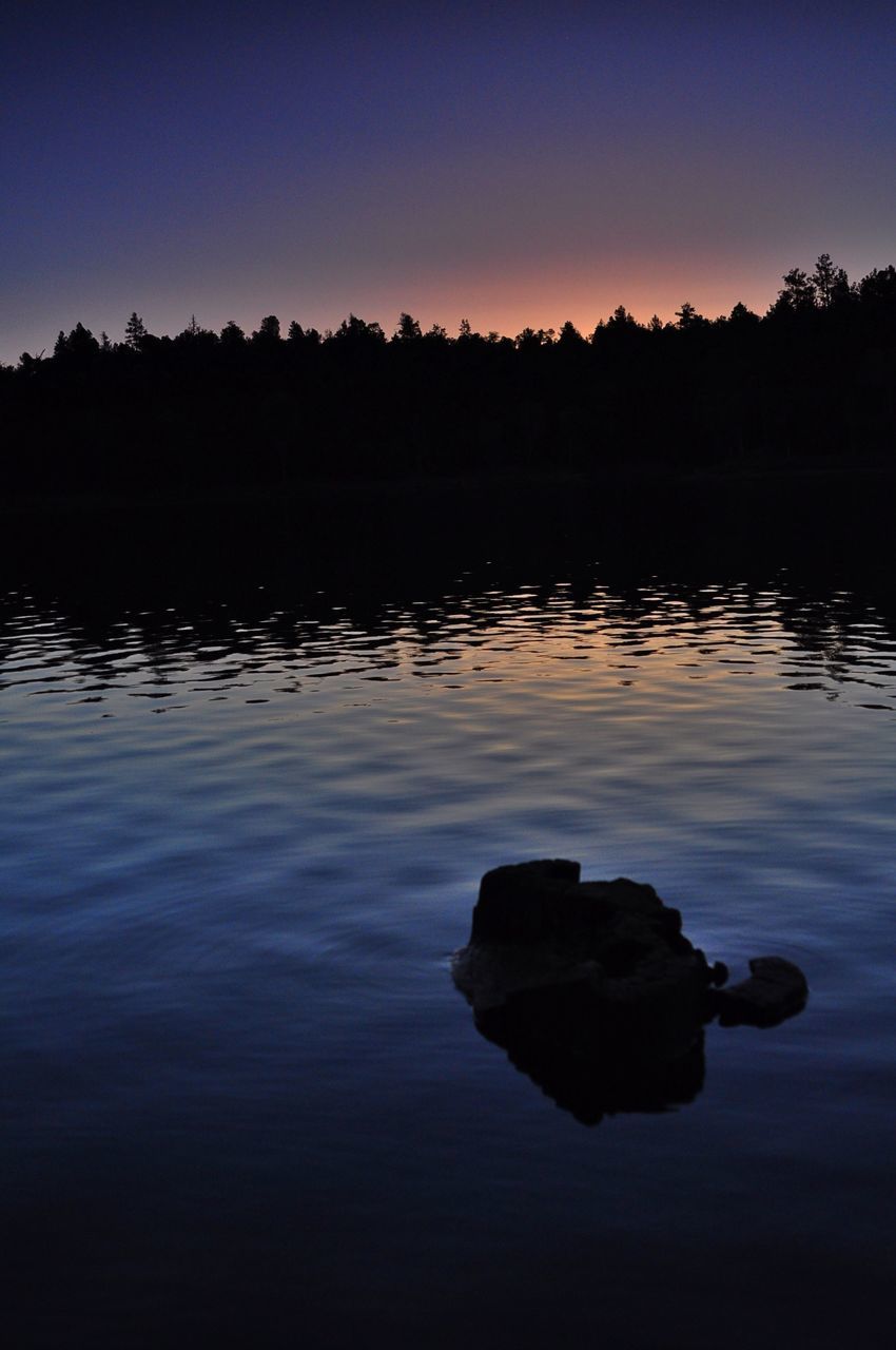 water, reflection, tranquil scene, tranquility, scenics, lake, beauty in nature, waterfront, sunset, silhouette, clear sky, nature, idyllic, rock - object, rippled, calm, sky, copy space, dusk, outdoors