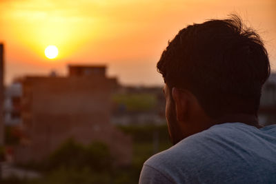 Rear view of man against sky during sunset