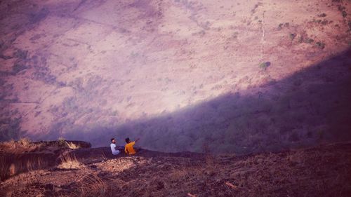 Two men sitting on mountain