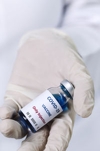 Close-up of hand holding vial