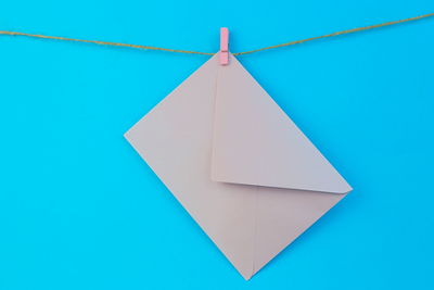 Close-up of paper hanging against blue background