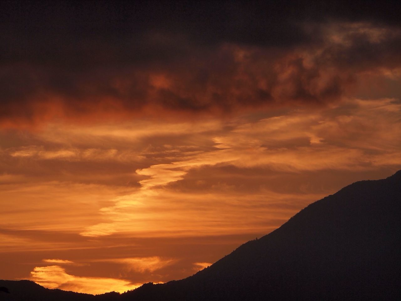 sunset, scenics, silhouette, beauty in nature, tranquil scene, sky, tranquility, mountain, orange color, cloud - sky, nature, idyllic, dramatic sky, mountain range, cloud, landscape, majestic, cloudy, outdoors, non-urban scene