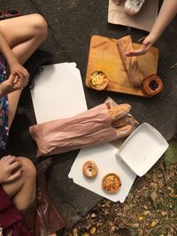 Low section of people holding food on table