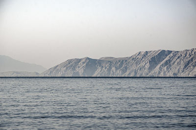 Scenic view of sea and mountains against clear sky