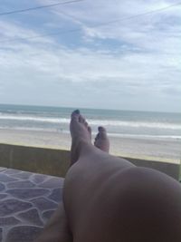 Low section of man relaxing on beach