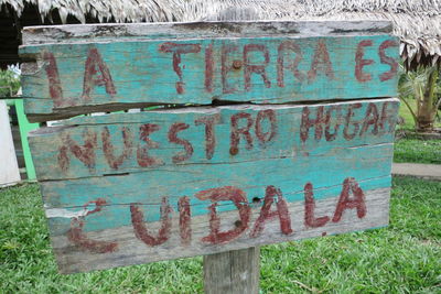 Close-up of old rusty sign on wood