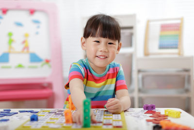 Portrait of cute boy with toy on table