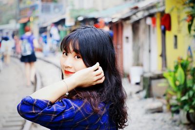 Side view portrait of smiling young woman in town