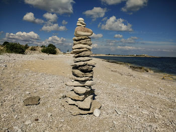 Stack of rocks on beach against sky