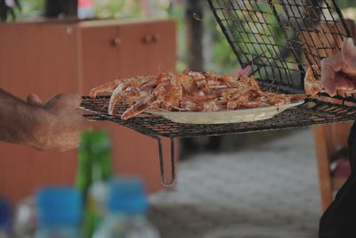 Midsection of person preparing food on barbecue grill