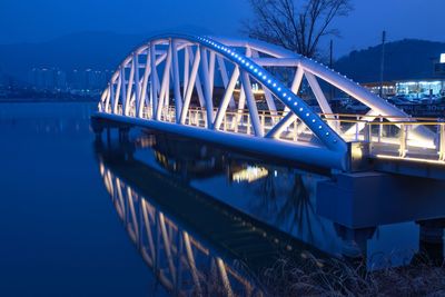 Bridge over river against sky at dusk