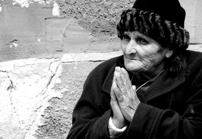 Close-up of senior woman with hands clasped