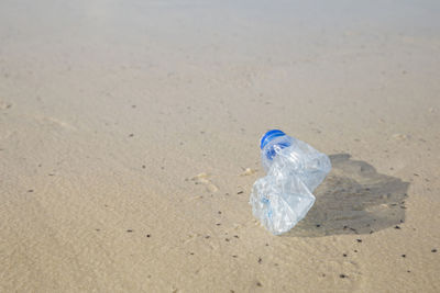 Garbage bin on sand at beach