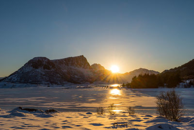 Scenic view of snowcapped mountains against sky during sunset