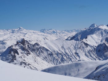 Scenic view of snowcapped mountains against clear blue sky