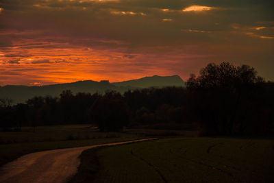 Scenic view of silhouette field against sky during sunset
