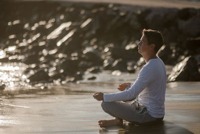 Man meditating on sea shore