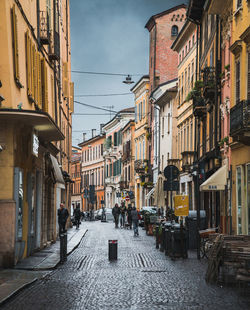 People walking on footpath amidst buildings in city