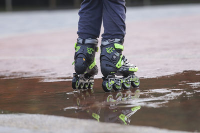 Low section of person skating on wet road