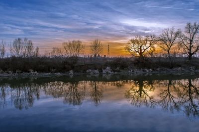 Reflection of trees in lake during sunset