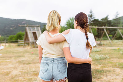 Rear view of friends standing on land