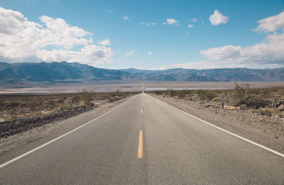 Road by landscape against sky