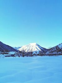 Scenic view of snowcapped mountains against clear blue sky