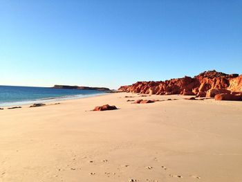 Scenic view of beach against clear blue sky