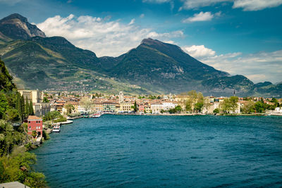 Scenic view of sea by townscape against sky