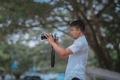 Side view of young man photographing