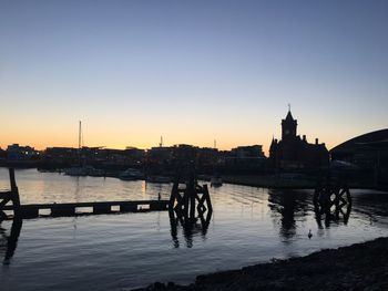 Silhouette of buildings at riverbank