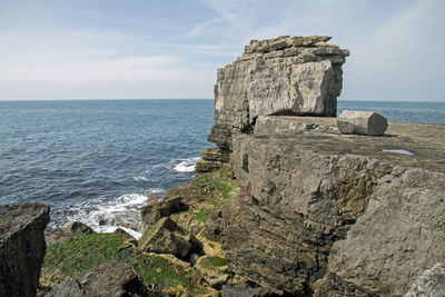 Scenic view of rock formation in sea against sky