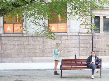 Full length of people sitting outside building