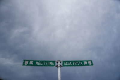 Low angle view of road sign against sky