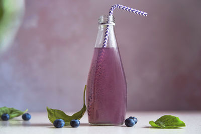 Natural vegan cocktail in bottle with blueberries, seeds, basil extract. soft refreshing drink