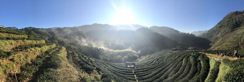 Panoramic view of mountains against bright sun