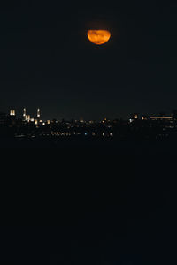 Illuminated cityscape against sky at night