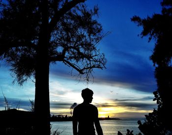 Silhouette of man looking at sunset