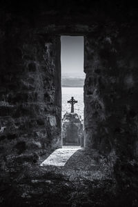 Silhouette man standing by window